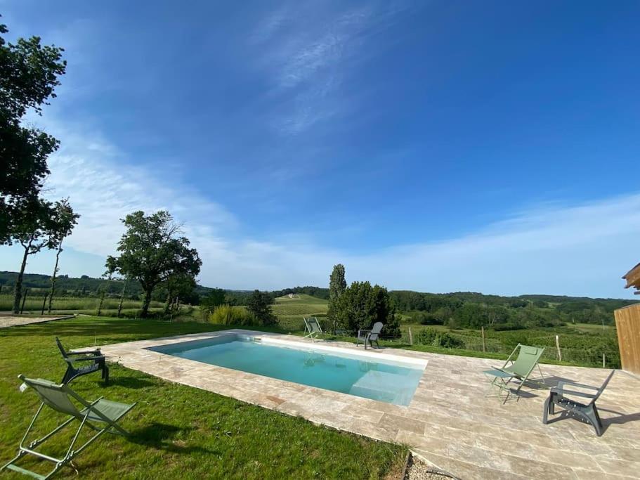 - une piscine dans une cour avec 2 chaises longues dans l'établissement Chai Nous ! Maison rénovée sur un domaine viticole proche de Saint Emilion, à Gardegan-et-Tourtirac