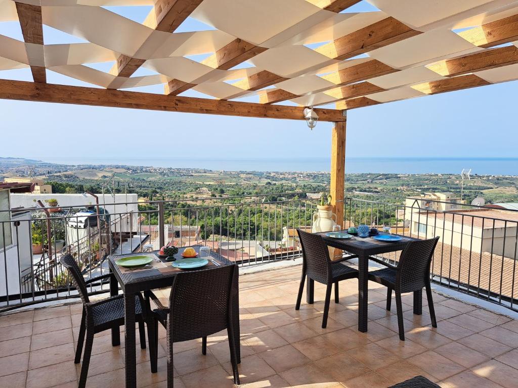 un patio con mesas y sillas en el balcón en B&B Gergent, en Agrigento