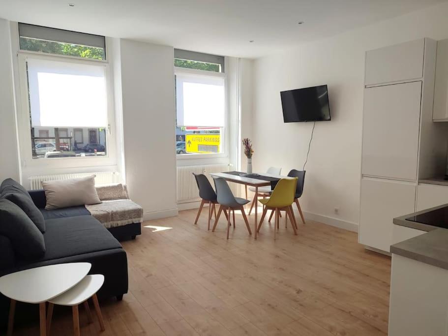 uma sala de estar com um sofá, uma mesa e cadeiras em Appartement Strasbourg Centre em Estrasburgo