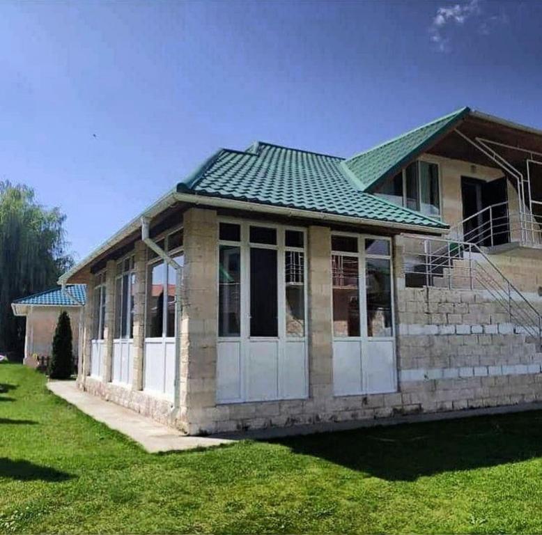 royal_beach_cottege في Chok-Tal: منزل صغير بسقف أخضر