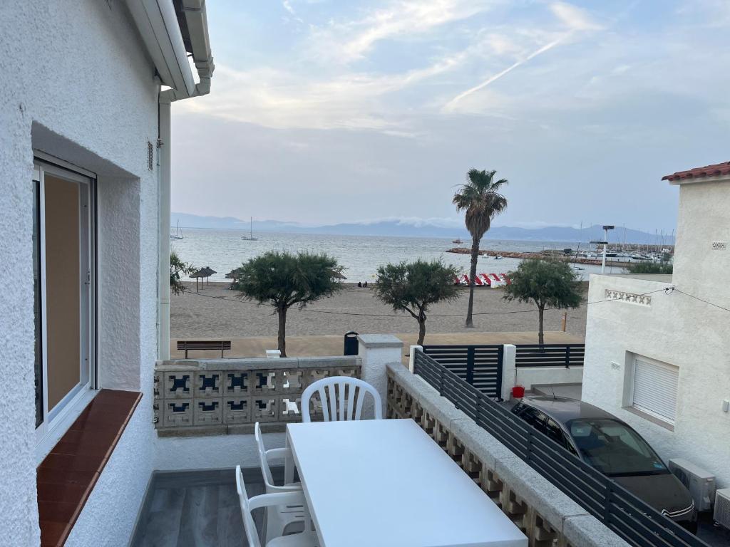 a balcony with a table and chairs and the beach at Apartamento en la playa. Free Parking. Free WiFi in L'Escala