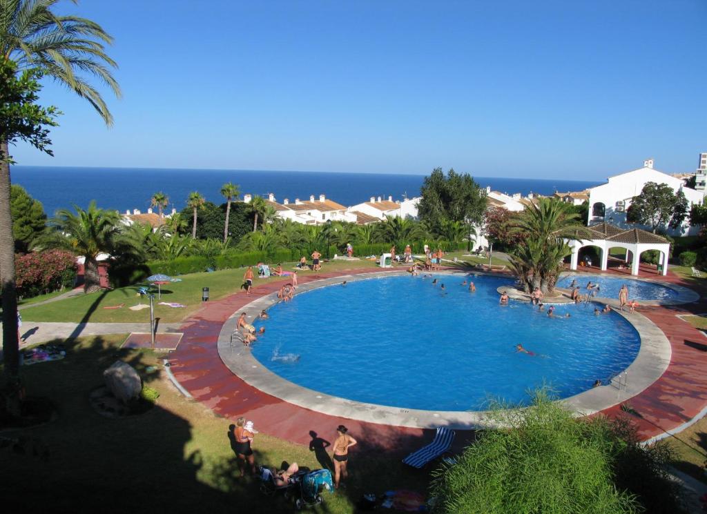 a large swimming pool in a resort with the ocean in the background at APCOSTAS - Gran Vista in Gran Alacant