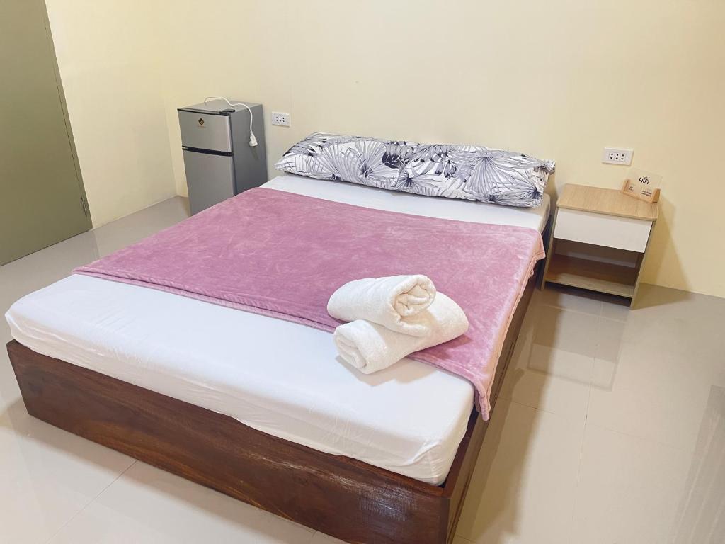sypialnia z łóżkiem z ręcznikami w obiekcie Summer room B w mieście Dumaguete