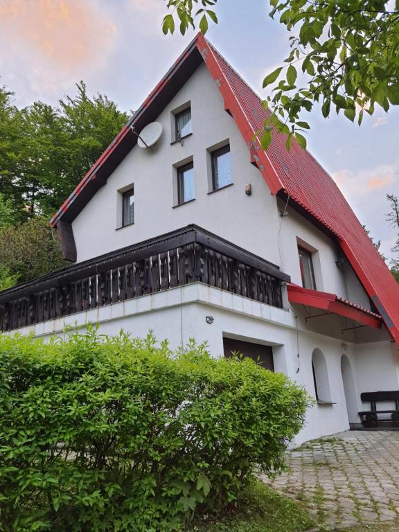 uma casa branca com um telhado vermelho em "Jurkówka" em Szczyrk