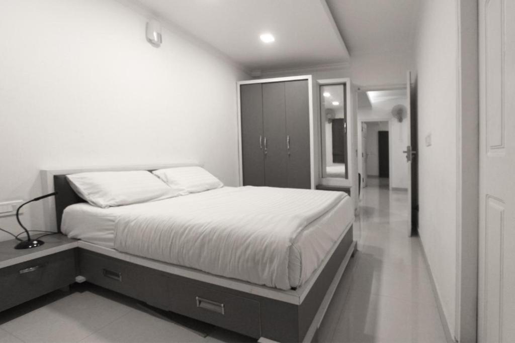 a bedroom with a large bed with white sheets at Livi Suites - Premium 1 BHK Serviced Apartments in Bangalore