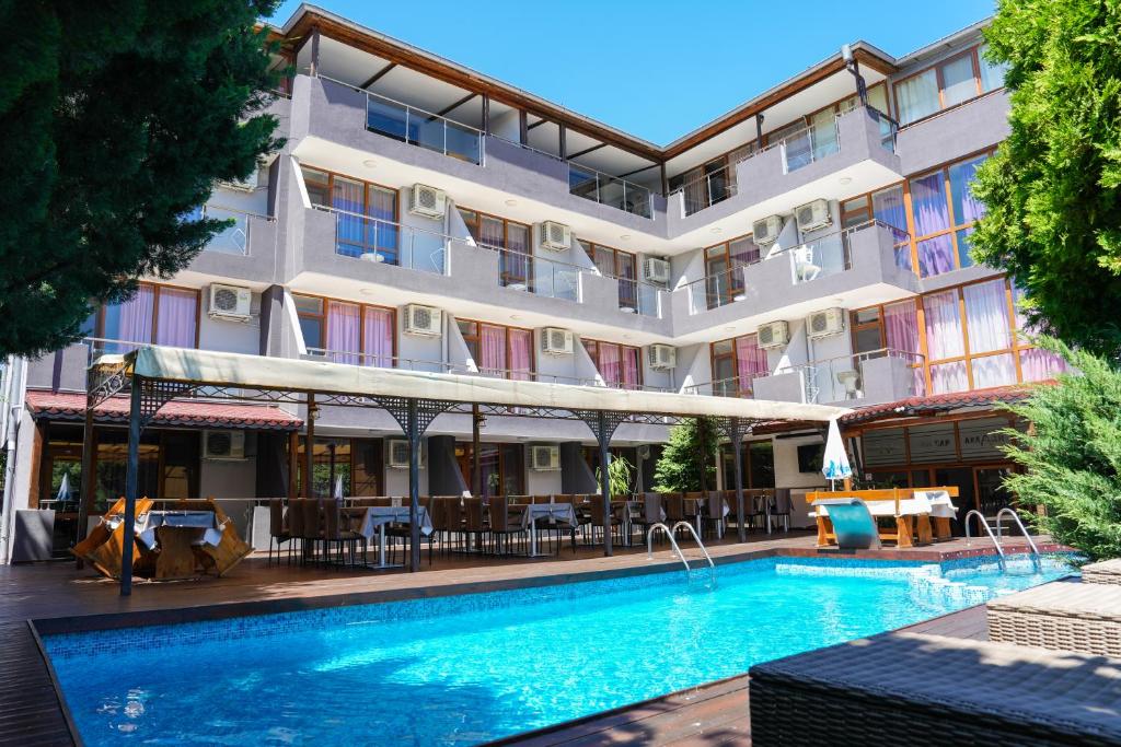 un hotel con piscina frente a un edificio en Akladi Family Hotel en Chernomorets