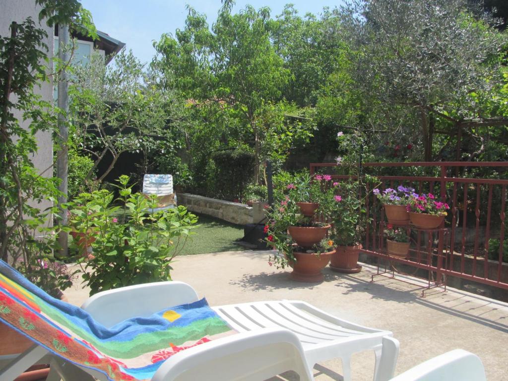 - une terrasse avec une table, des chaises et des fleurs dans l'établissement Apartment Artusi, à Pula