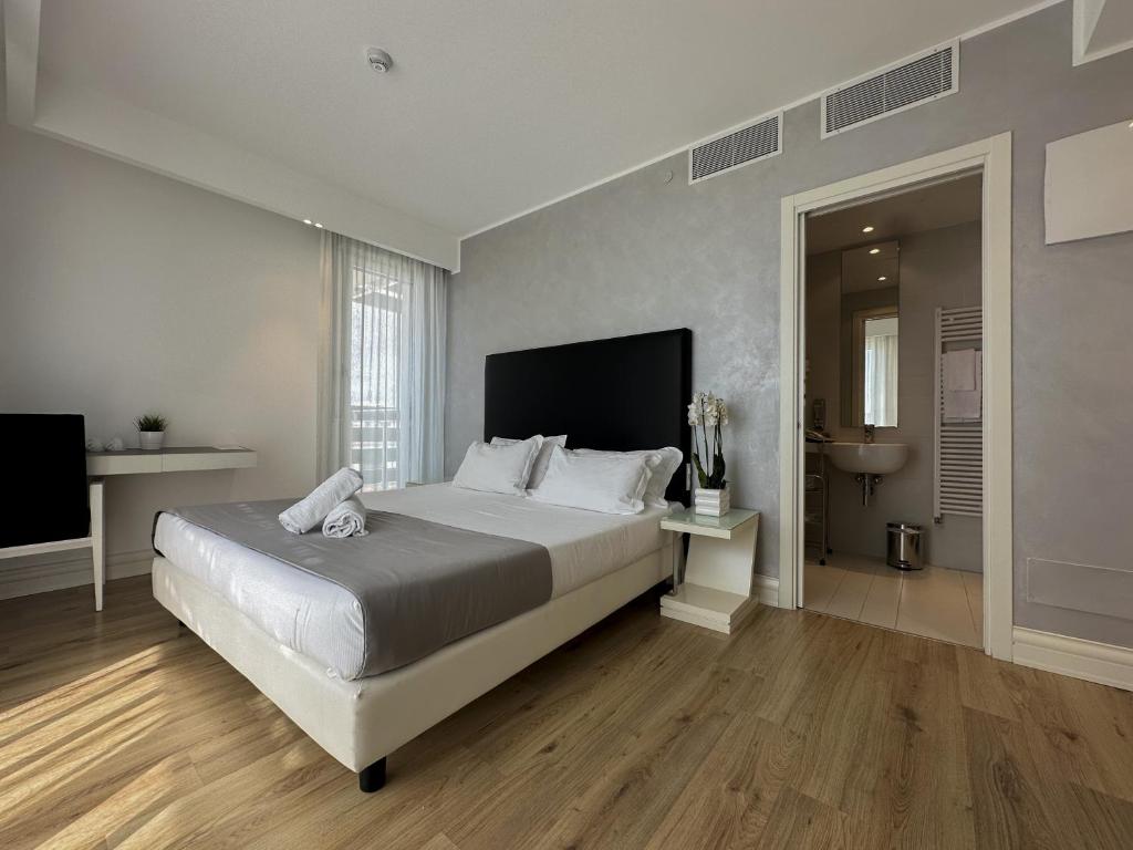 a bedroom with a large bed and a television at Boutique Hotel Bali in Lido di Jesolo