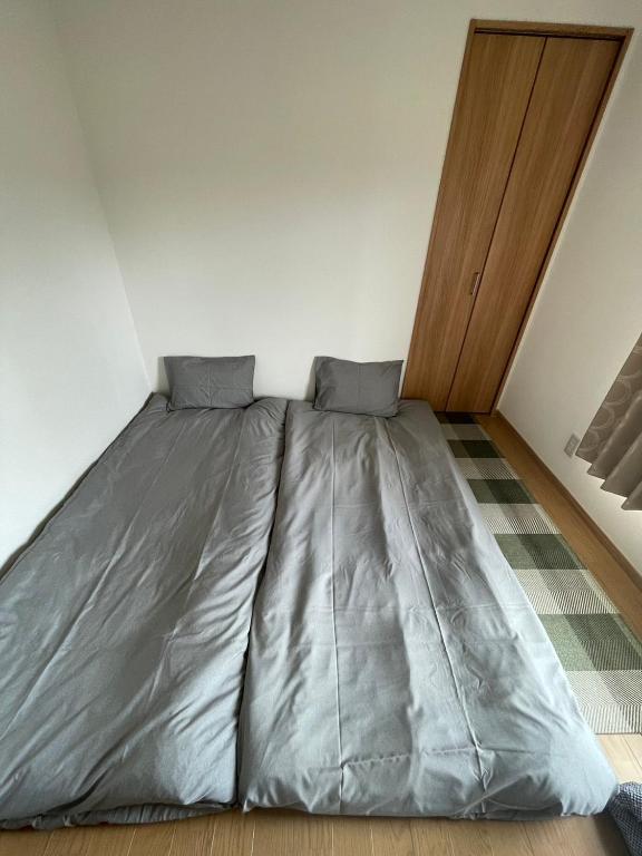 Postel nebo postele na pokoji v ubytování 青梅森の宿