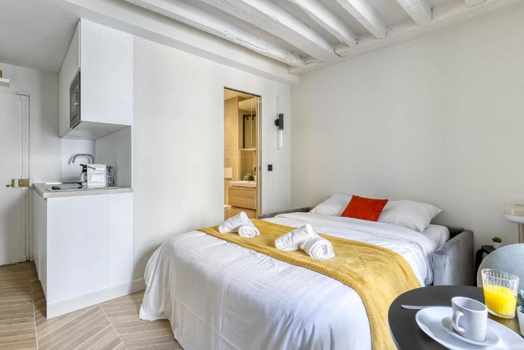a white room with two beds and a kitchen at New and Designed Studio well Equipped - Heart of Paris 2 in Paris