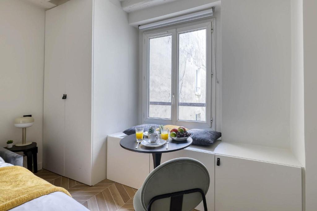a small table in a room with a window at New and Designed Studio well Equipped - Heart of Paris 2 in Paris