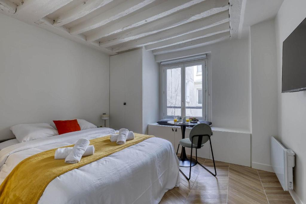 a white bedroom with a large bed and a desk at New and Designed Studio well Equipped - Heart of Paris 2 in Paris