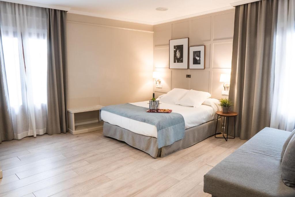 a hotel room with a bed and a couch at Hotel Doña Blanca in Jerez de la Frontera