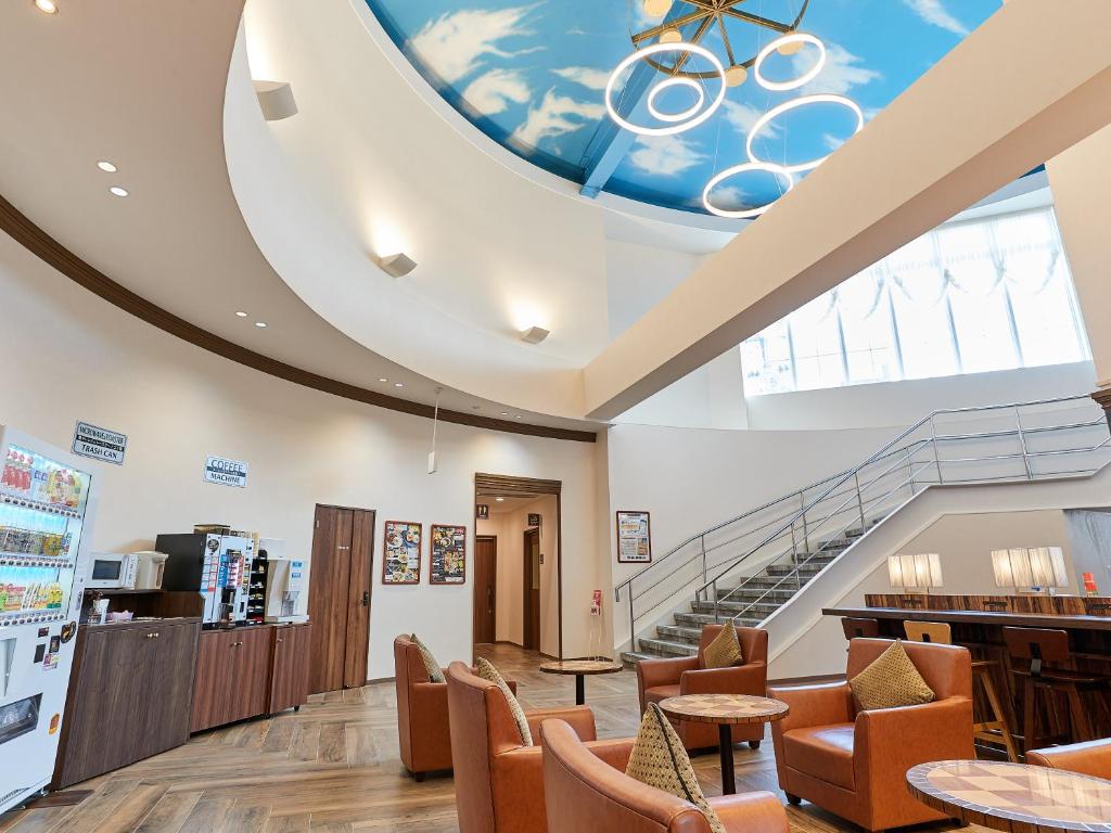 a waiting room with chairs and a spiral staircase at Grand Cabin Hotel Naha Oroku in Naha