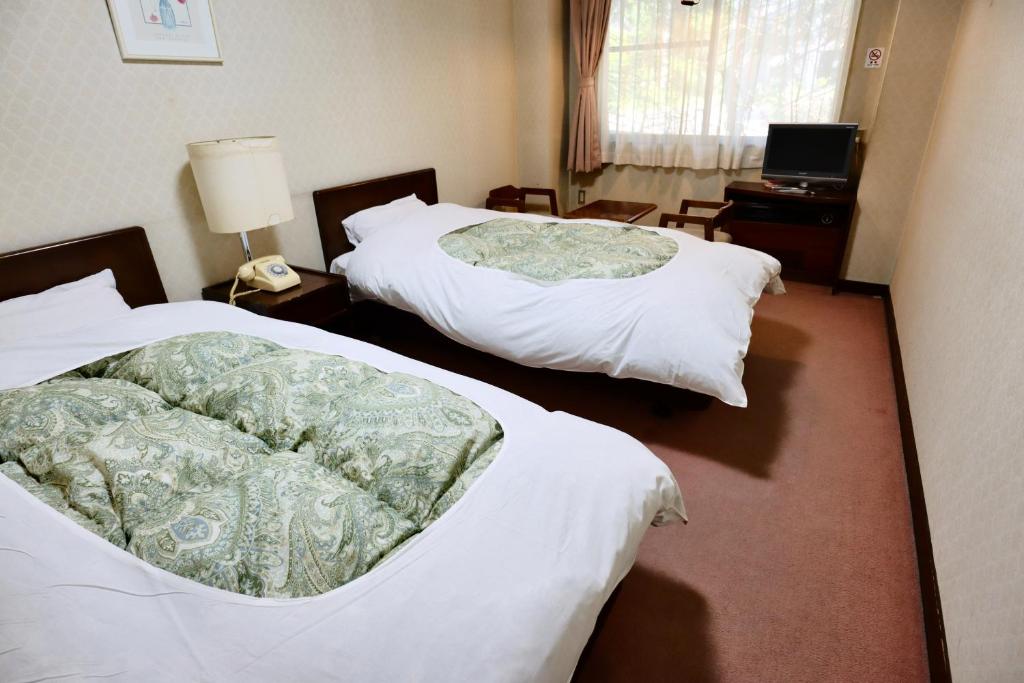 Postel nebo postele na pokoji v ubytování Hakuba Park Hotel