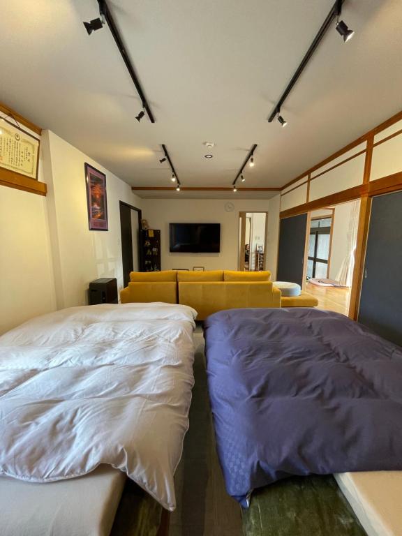 uma sala de estar com duas camas e um sofá em Boss'sHouse犬ok天然温泉あり em Kirishima