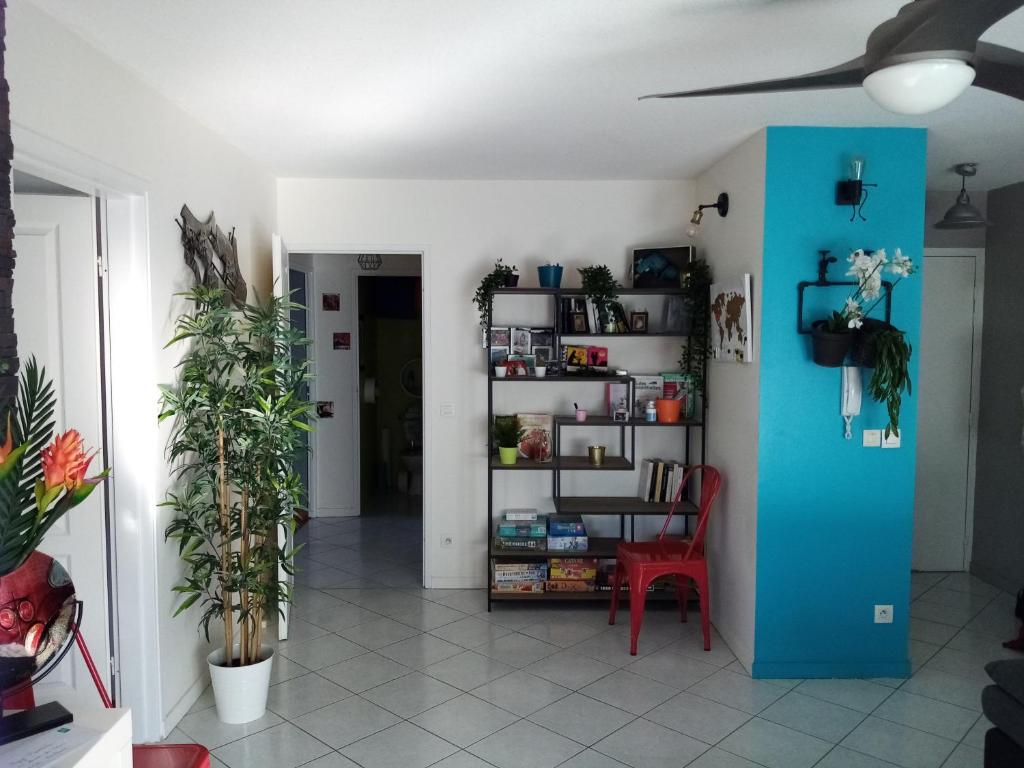 uma sala de estar com uma divisória azul e uma cadeira vermelha em Chambre dans appartement Saint Martin d'Hères près du Campus em Rhut