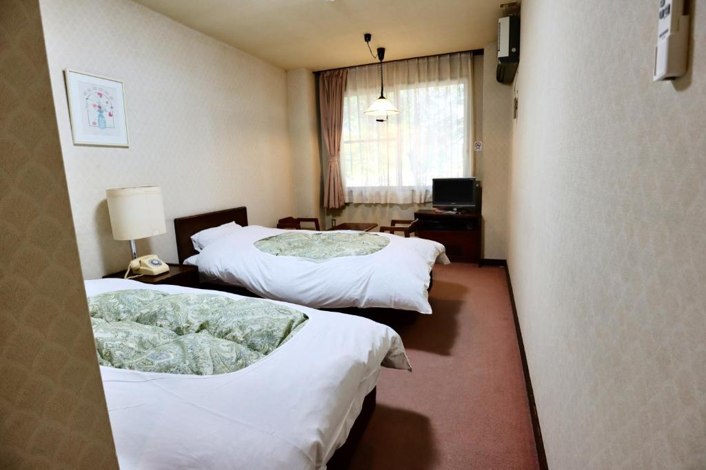 Postel nebo postele na pokoji v ubytování Hakuba Park Hotel