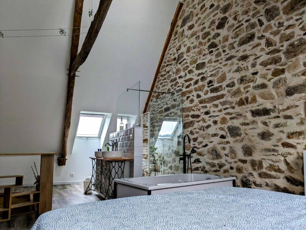 a room with a stone wall and a sink at Le Quatorze, au cœur de Najac in Najac