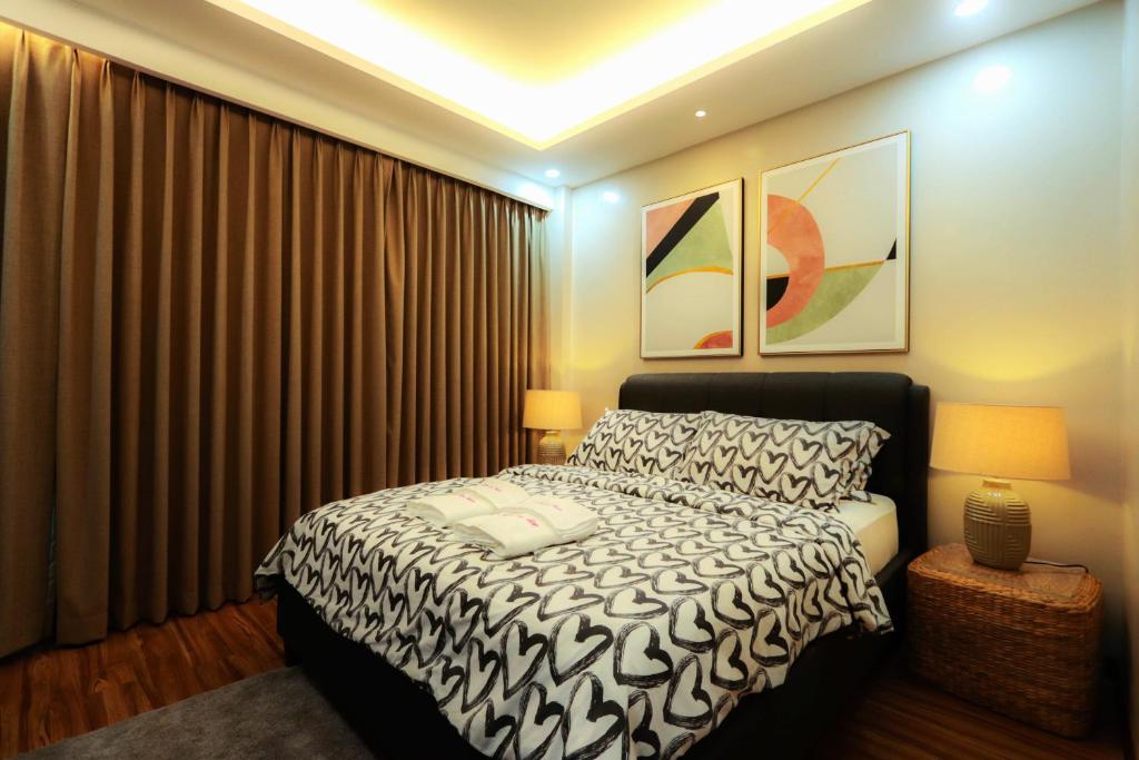a bedroom with a black and white bed and curtains at Gloria Tree Mayon and Park View Residences in Legazpi