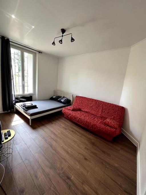 sala de estar con sofá rojo en el suelo de madera en Appartement GARE Juvisy*ORLY AIRPORT*Paris en Juvisy-sur-Orge
