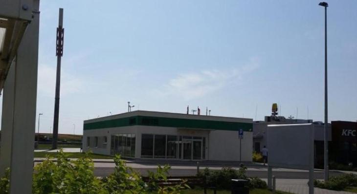 een gebouw met een groen dak op een parkeerplaats bij Motel Stare Brynki przy stacji BP Trójka 