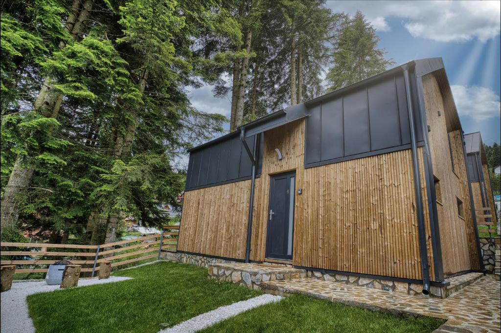 a wooden house with a black roof at Norway Cabins in Sinaia