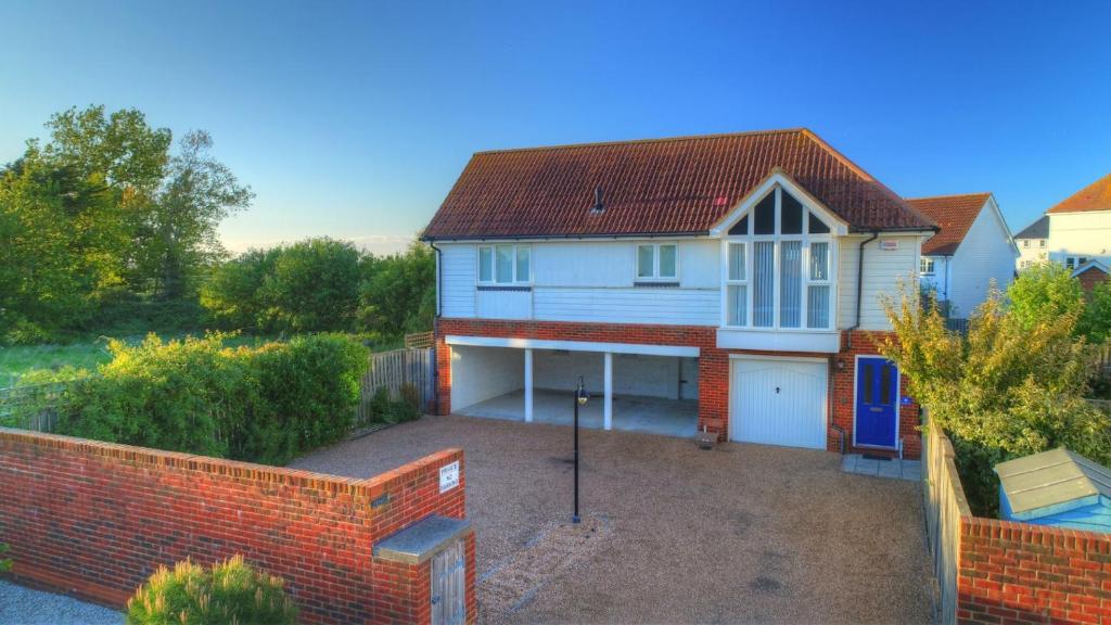 a white house with a garage and a driveway at Sail Loft in Camber