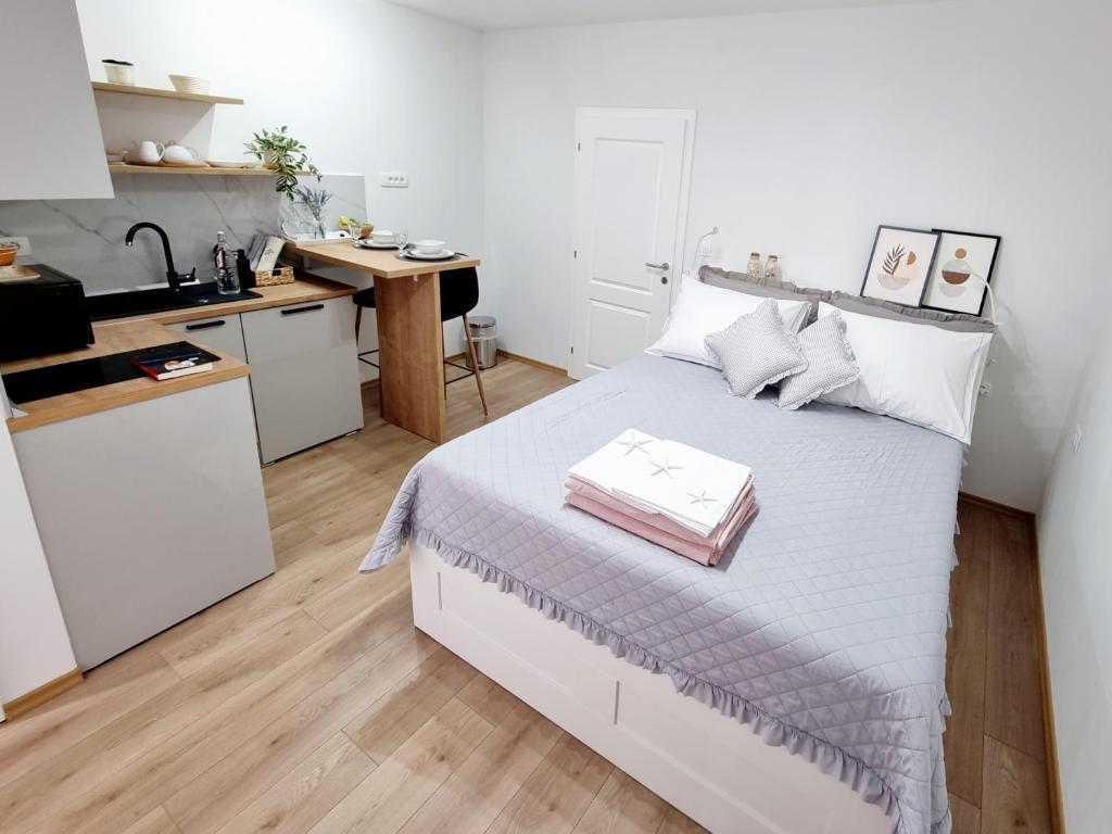 Cet appartement comprend une chambre avec un lit blanc et une cuisine. dans l'établissement Vila Damir, à Gradac