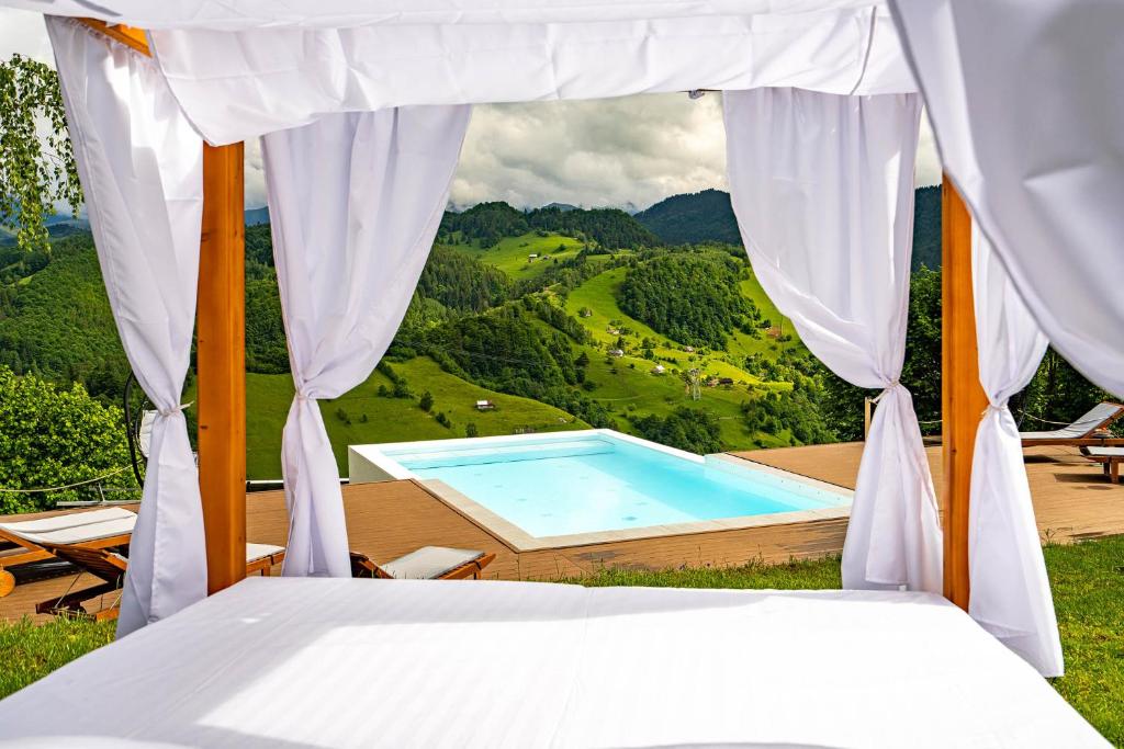 a bed with a view of a swimming pool at StockEstate Moieciu in Moieciu de Jos