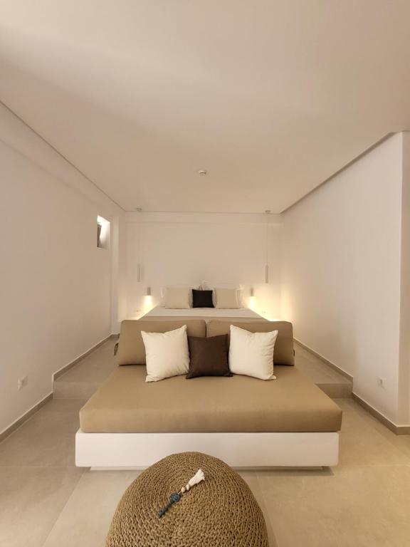 um quarto com uma cama grande e paredes brancas em ANEMOLETHE em Kimolos