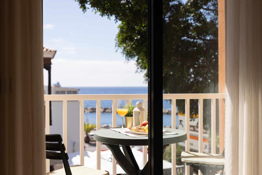 einen Tisch mit einem Teller mit Speisen und Getränken auf dem Balkon in der Unterkunft La Negrita en San Andrés cerca de la playa y WIFI in Santa Cruz de Tenerife