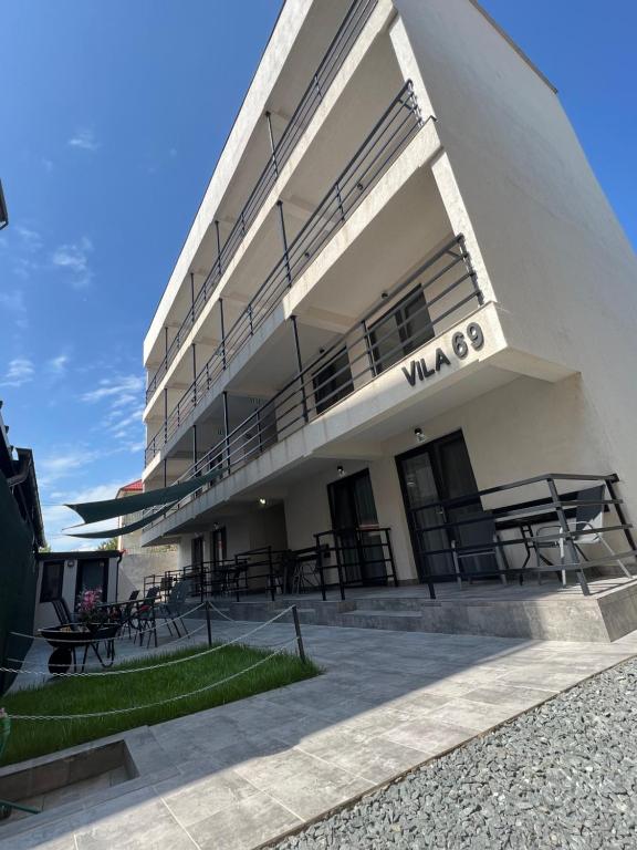a building with tables and chairs in front of it at Vila 69 in Costinesti