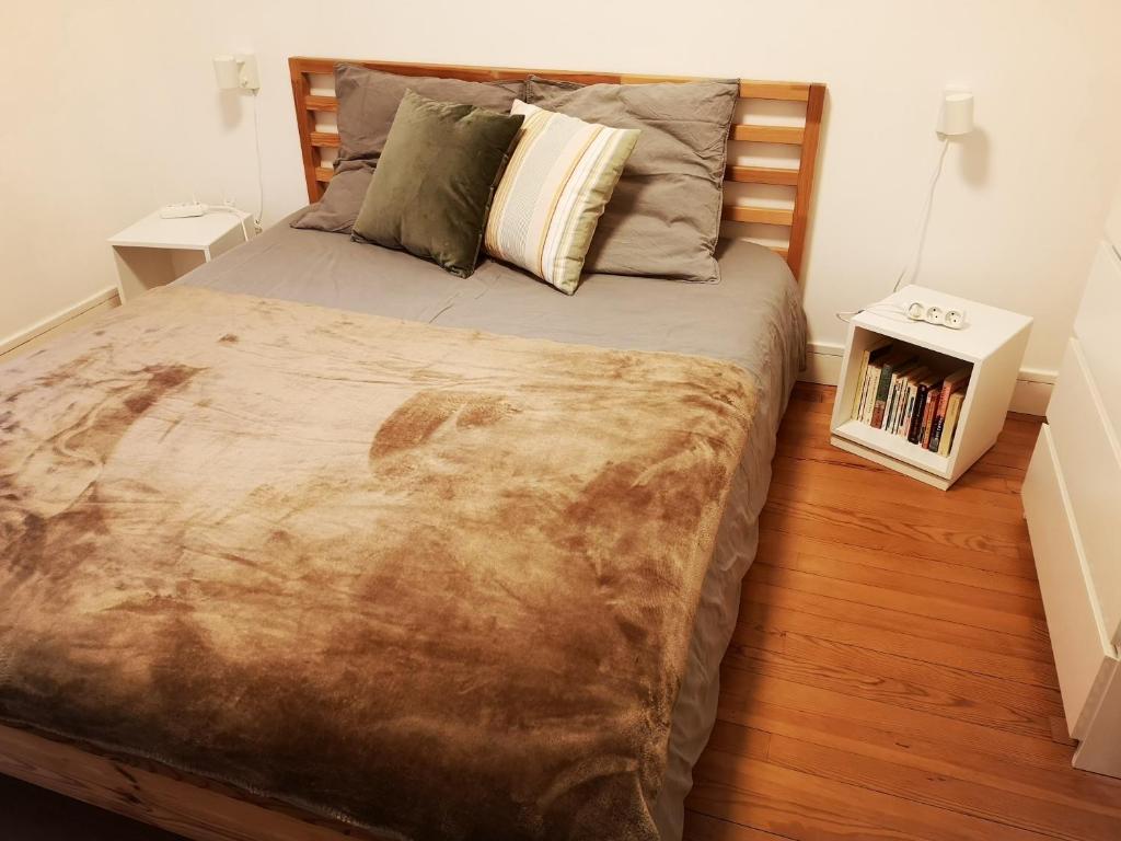 een slaapkamer met een groot bed met een houten hoofdeinde bij LE HARAS in Libourne