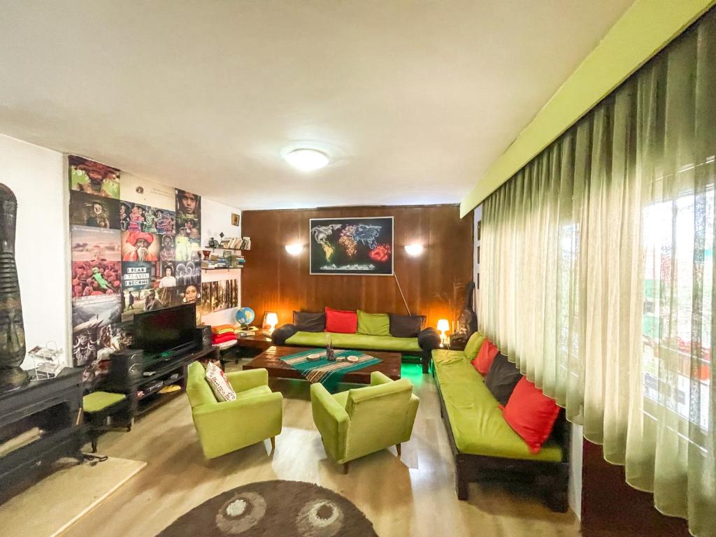 a living room with a green couch and green chairs at Hi Skopje Hostel in Skopje