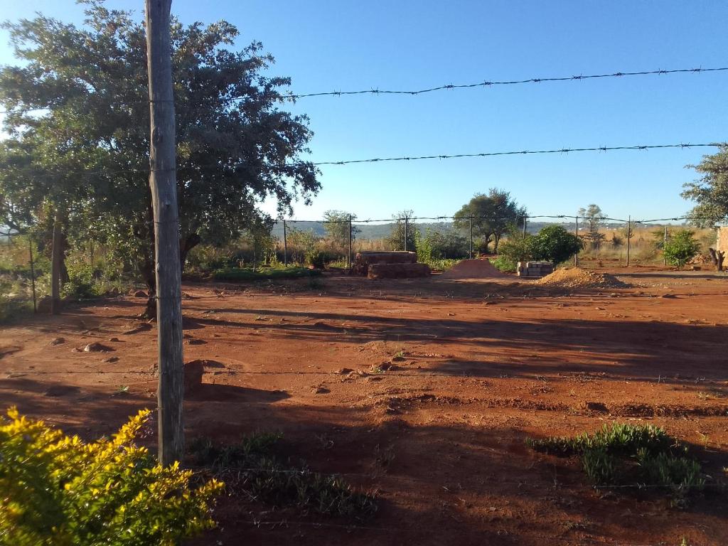 a dirt road with a telephone pole in a field at KGOLA SAFARIS in Rosslyn