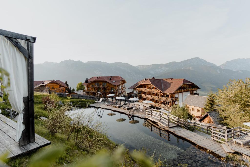 a bridge over a body of water next to houses at Natur- und Wellnesshotel Höflehner in Haus im Ennstal