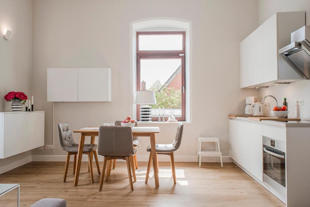 a kitchen and dining room with a table and chairs at Helle Stuuv in Lemkenhafen auf Fehmarn