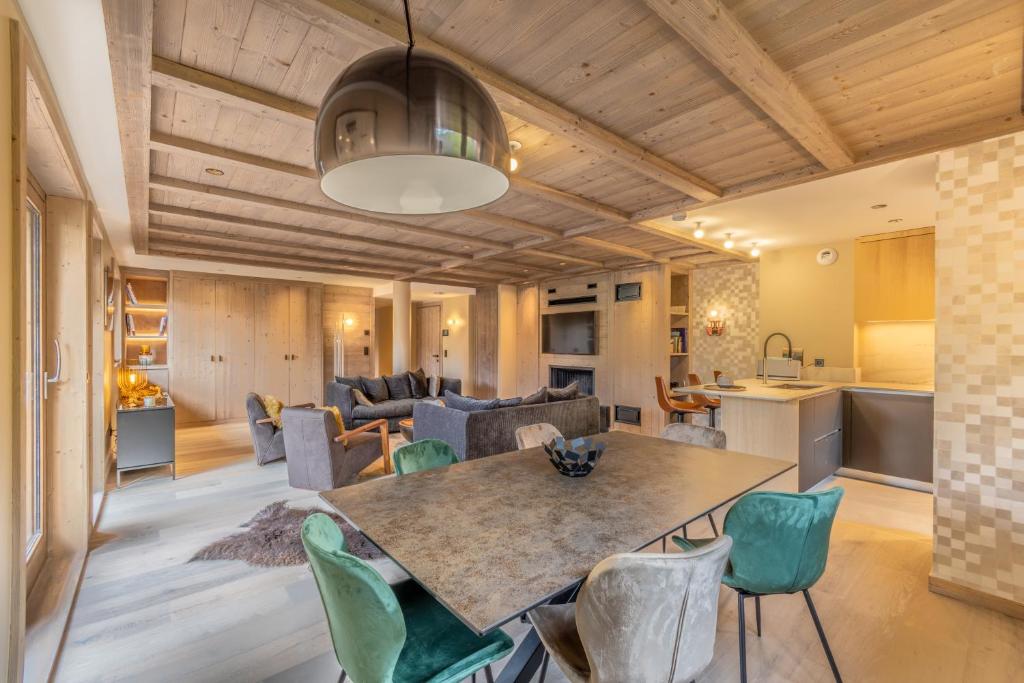 a kitchen and living room with a table and chairs at Bleu Eskape - Appartement in Megève