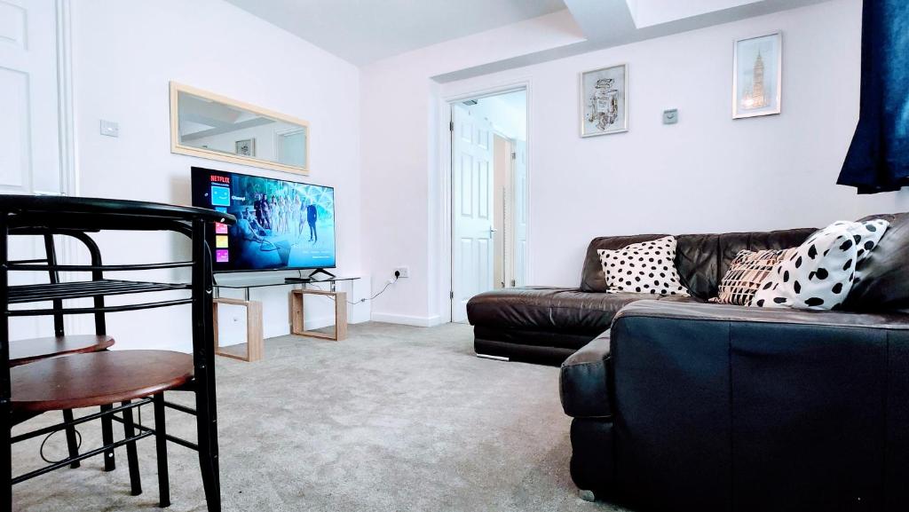 uma sala de estar com um sofá e uma televisão em 1 Bedroom Annex - Close to Frimley Hospital - Private Entrance em Frimley