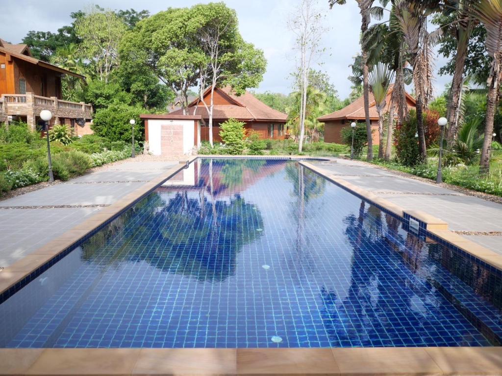 a swimming pool with blue tiles in a house at Sasidara Resort Nan in Nan
