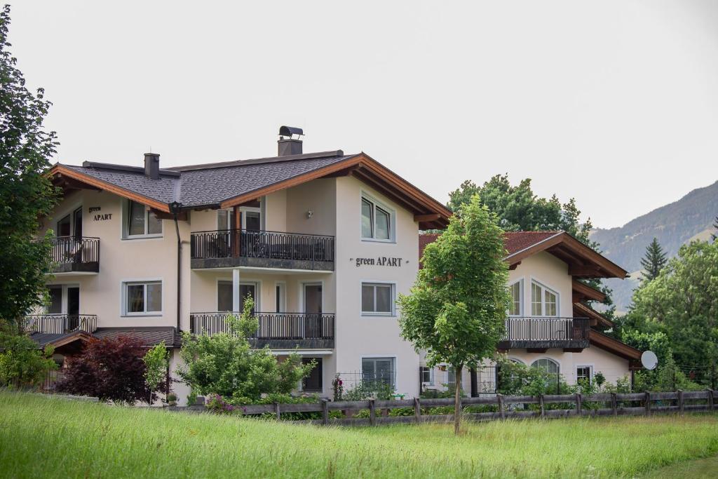 un grande edificio bianco con balconi e alberi di Green Apart a Uderns