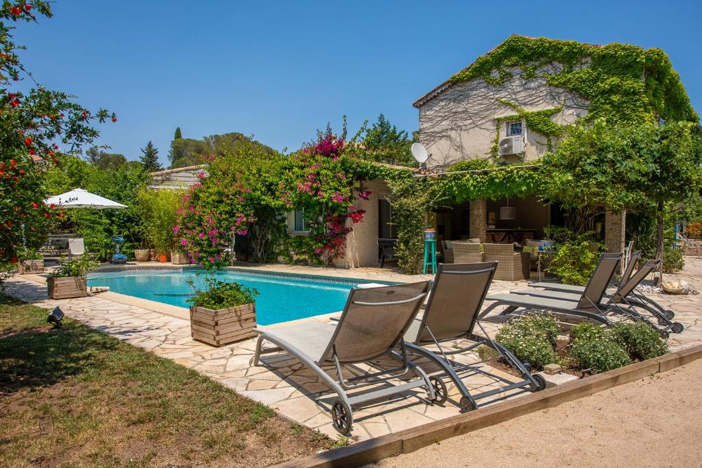 Un grupo de sillas junto a una piscina. en Villa provençale proche de la mer, en Boulouris-sur-Mer