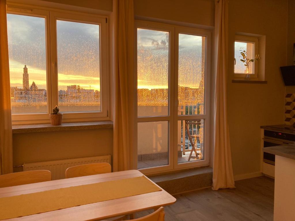 a room with windows with a view of a city at Apartament Zachody nad Wrocławiem in Wrocław