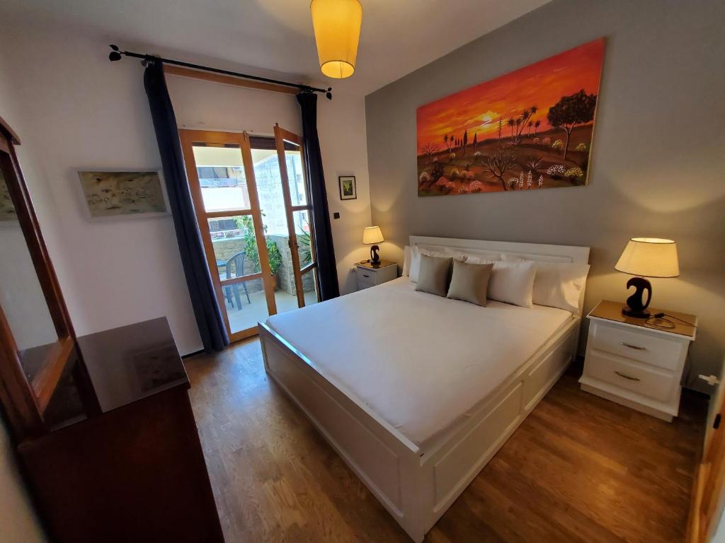 a bedroom with a white bed with a painting on the wall at Beautiful apartement in the heart of tangier in Tangier