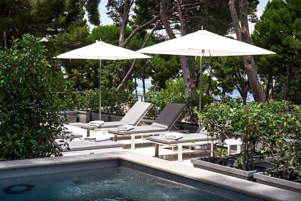 - une piscine avec 2 parasols et des chaises dans l'établissement A11 - Villa Cap Antibes Sea View 5 BDR - AC, Rooftop Pool & Parking, à Antibes