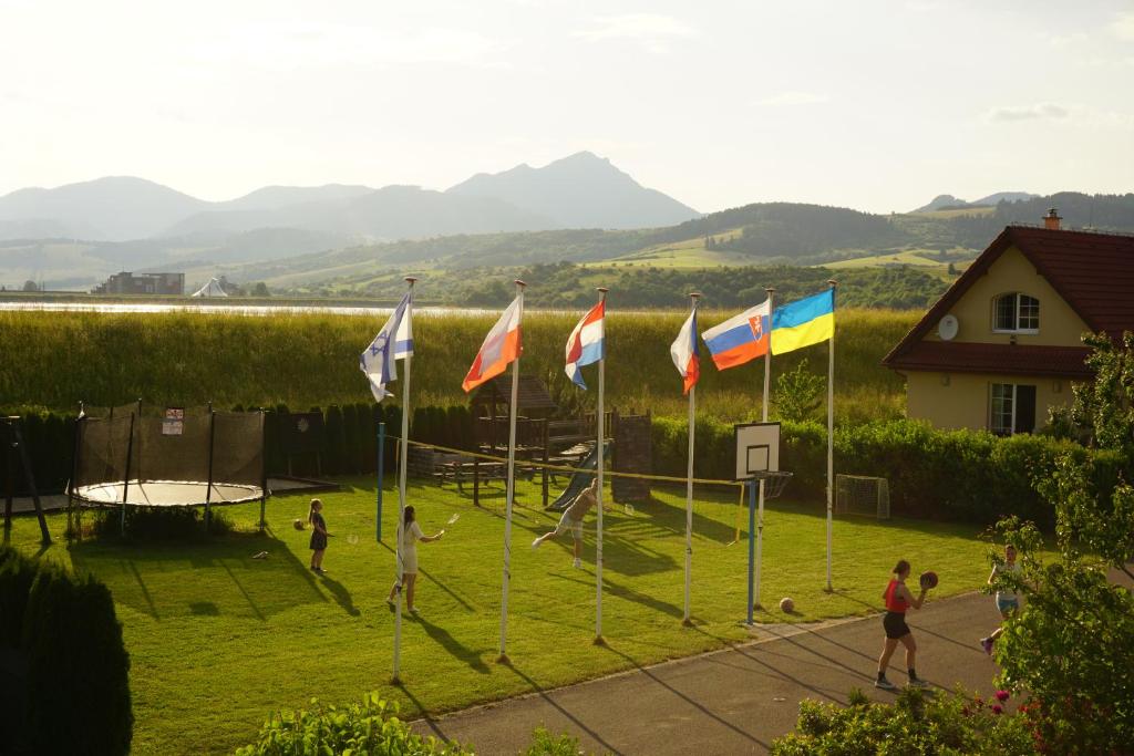 a group of people playing basketball in a field with flags at Villapark Vlašky in Bešeňová