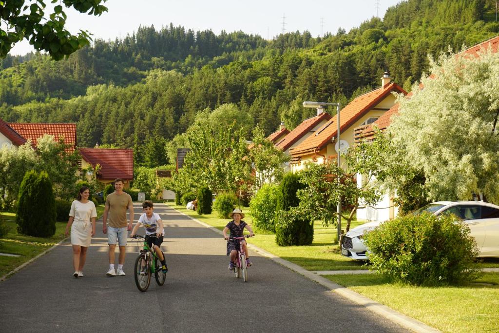 Villapark Vlašky في بشنوفا: عائلة تركب دراجاتهم في شارع