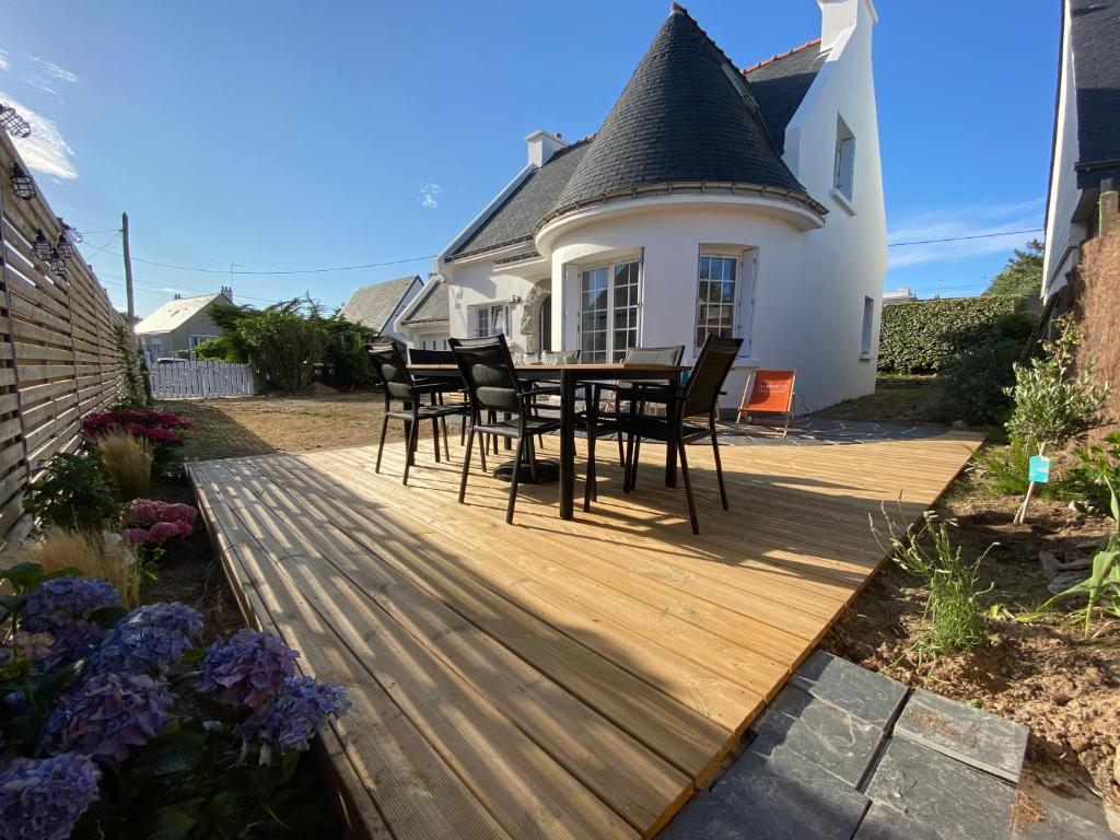 une terrasse en bois avec des chaises et une table sur une maison dans l'établissement Quiberon, à Quiberon