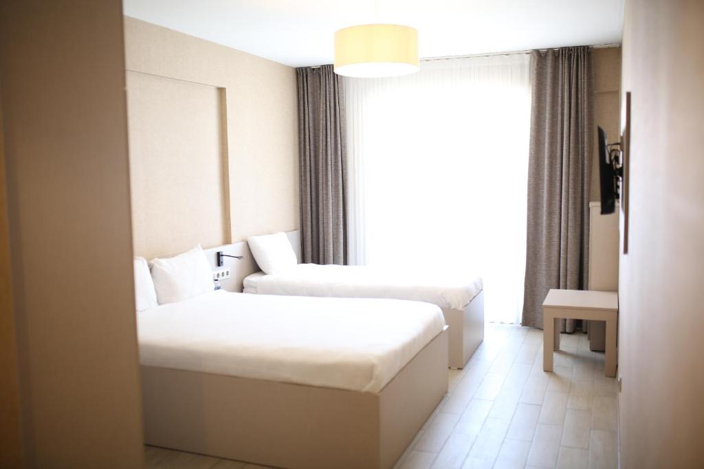 une chambre d'hôtel avec deux lits et une fenêtre dans l'établissement Hotel Cinas, à Eskişehir
